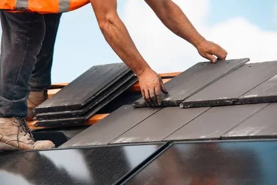 Roofer installing new roofing material on a Calgary home