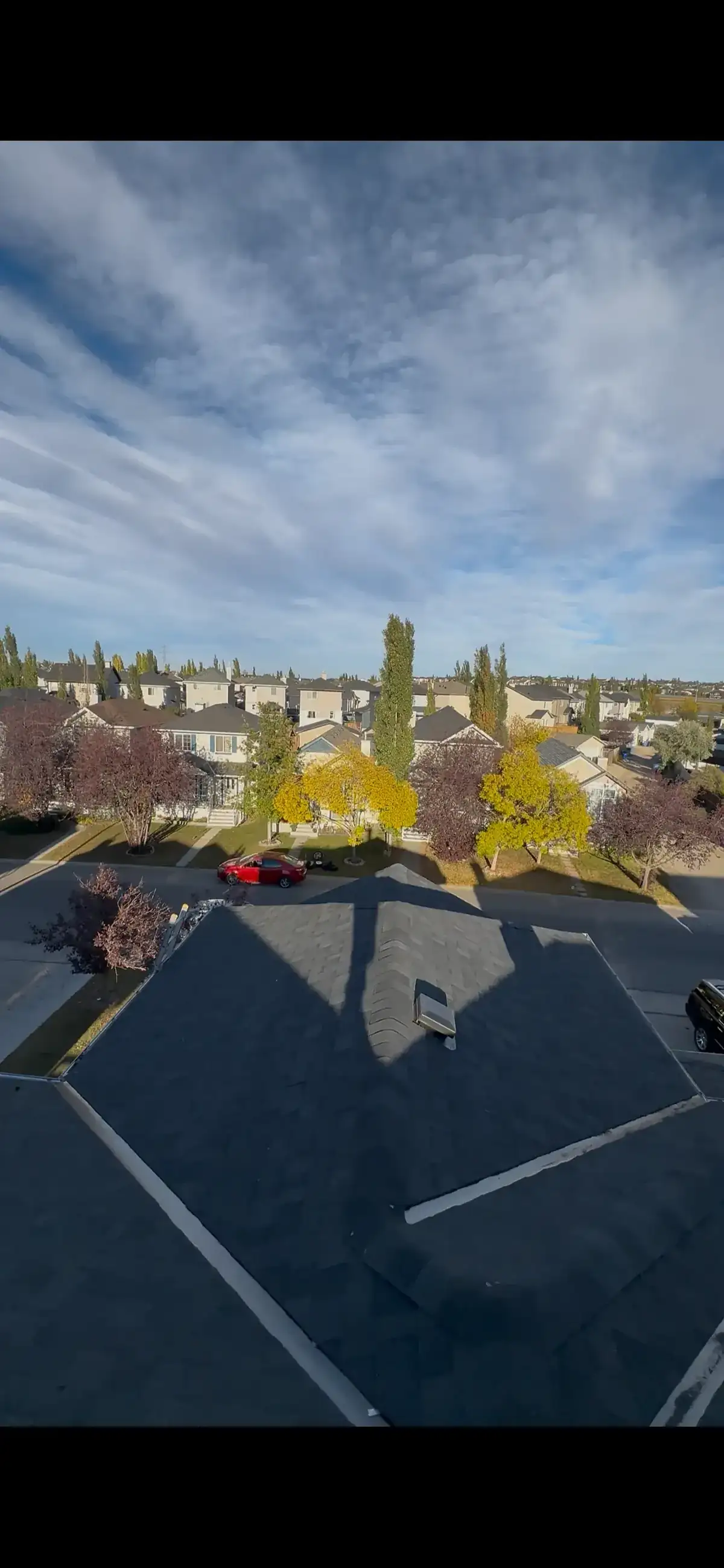 Aerial sunset view of a completed shingle roof installation in Calgary