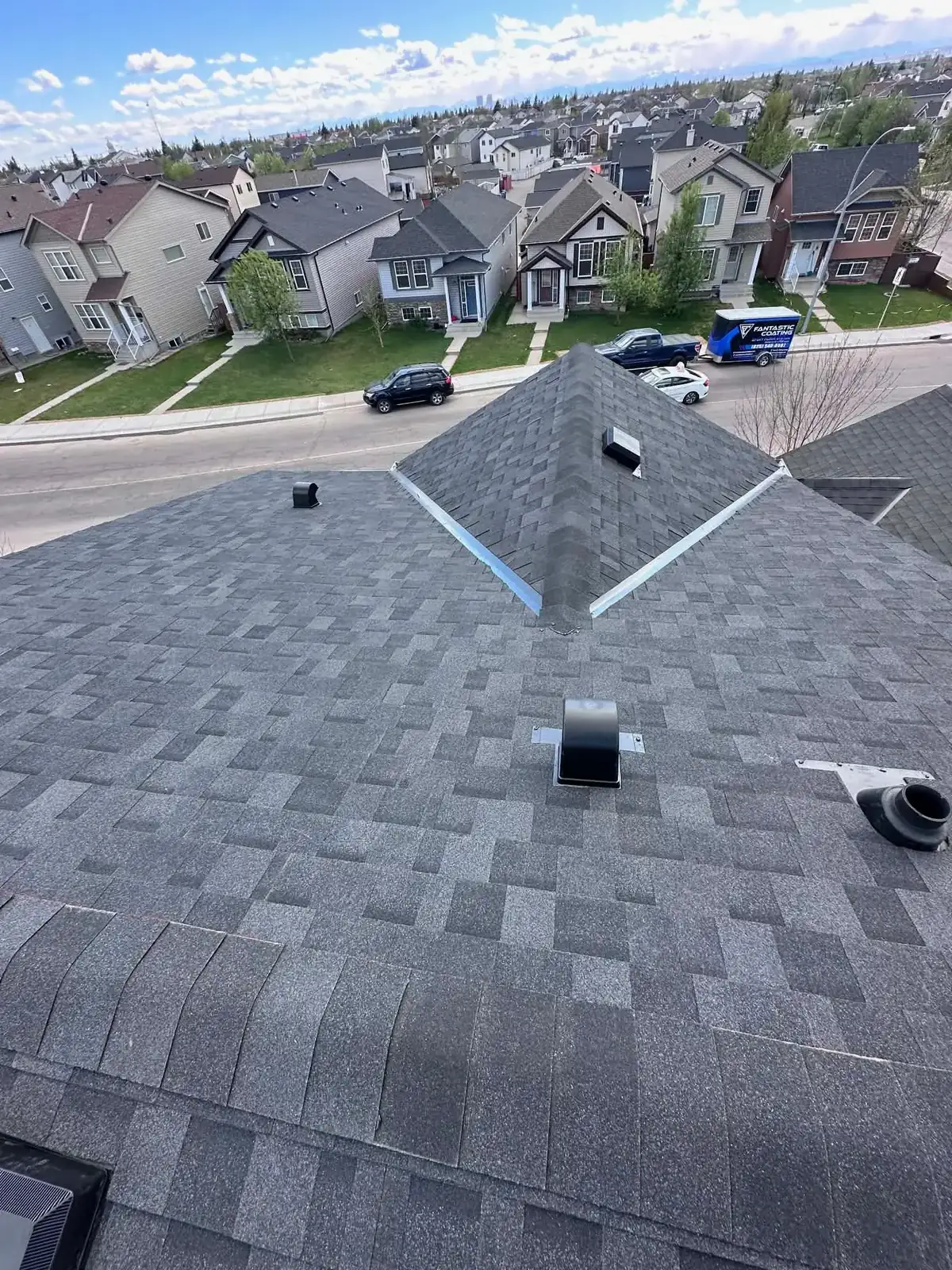 New shingle roof peak and vent installation on a Calgary home